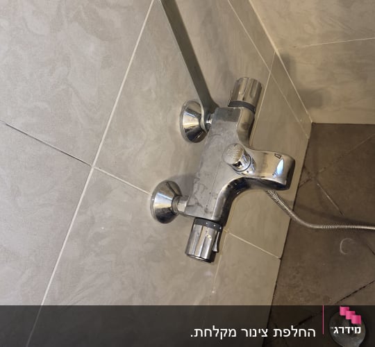 ברז מקלחת עם כלי עבודה על הרצפה